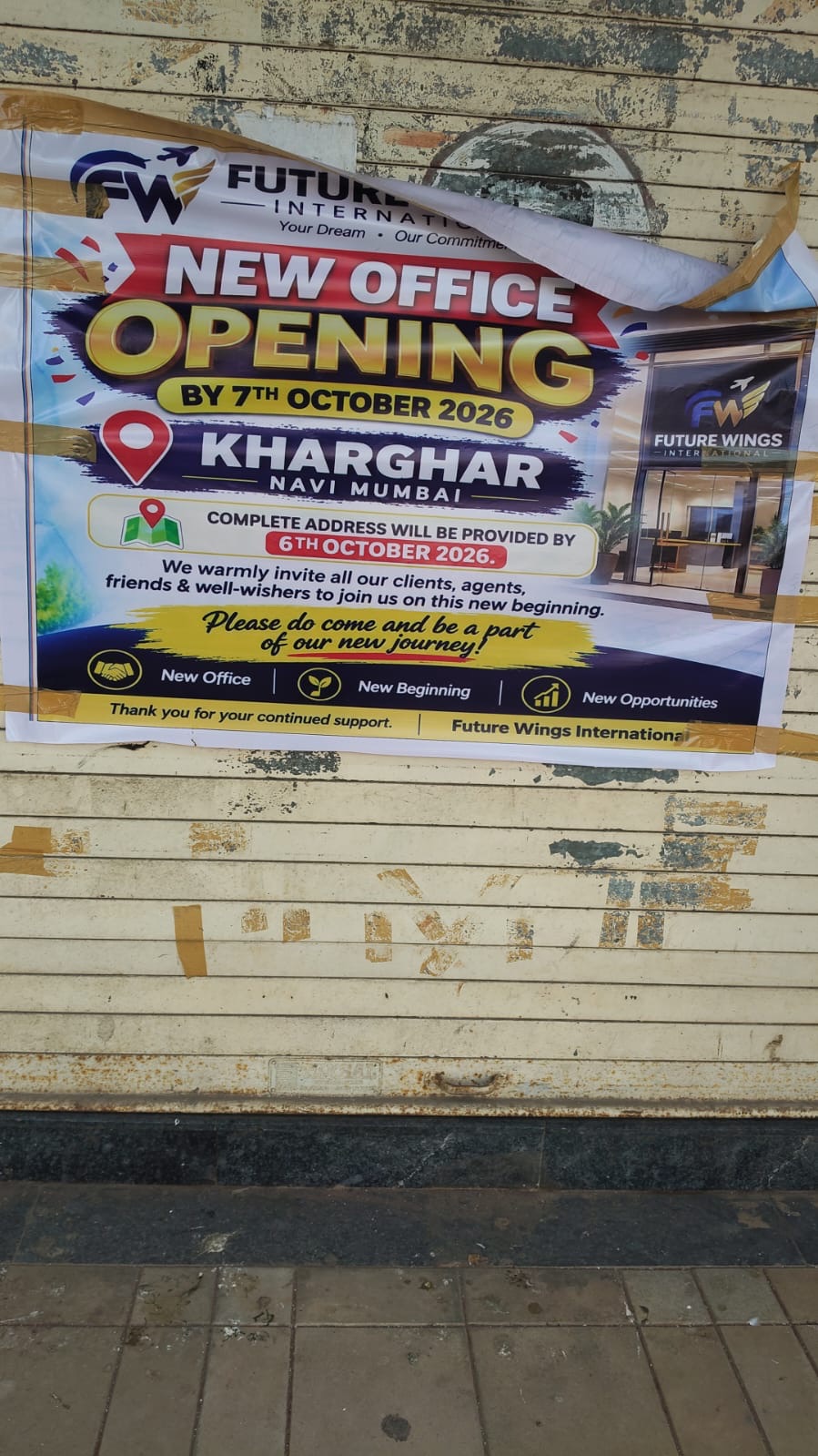 Poster on a shutter announcing a Future Wings International new office opening in Kharghar, Navi Mumbai, by 7 October 2026