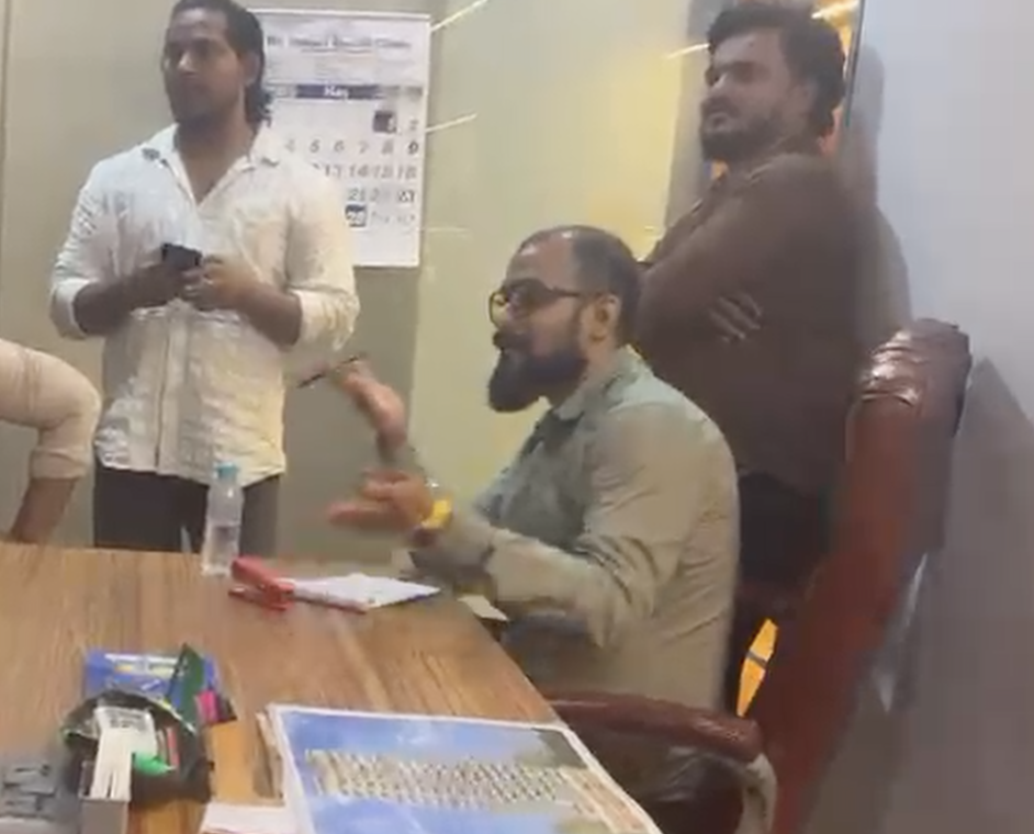 Sumit Choudhari seated at a desk with Vinodkumar Prajapati (Vicky) and Dilshad Pathan standing in the reported Future Wings office